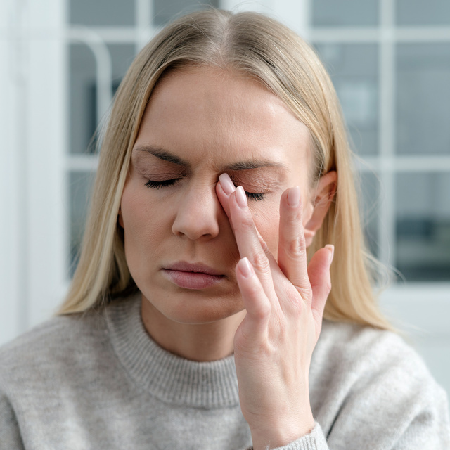 woman rubbing eye